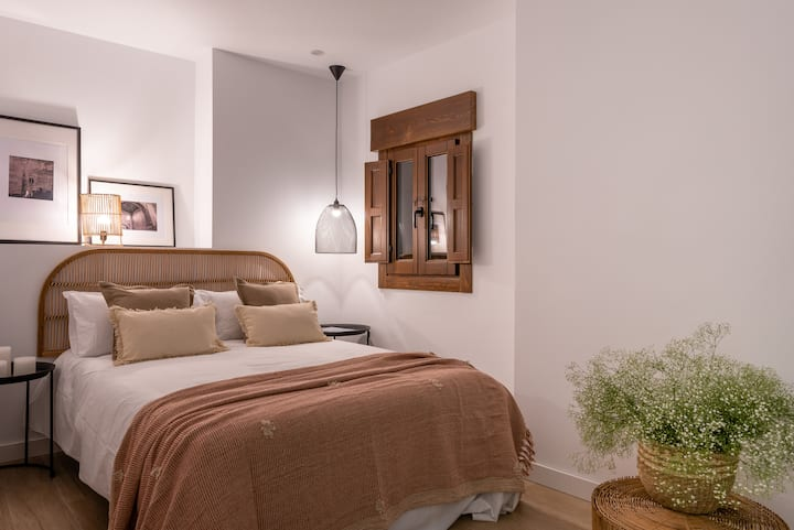 Dormitorio de Alcazaba con cama de matrimonio y cabecero de ratán