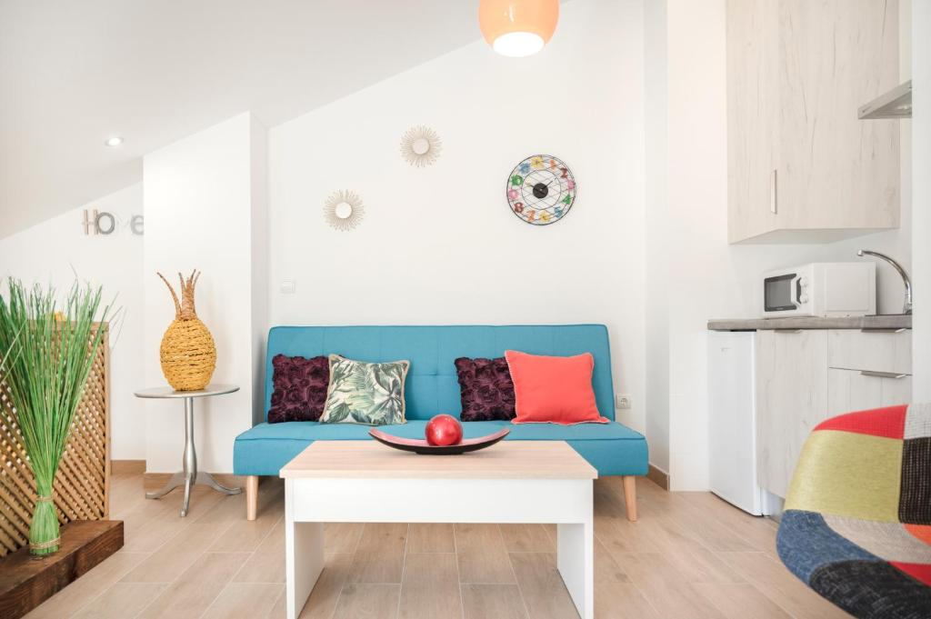 Zona de estar con sofá y cocina del Estudio con terraza de Alhambra Mesones