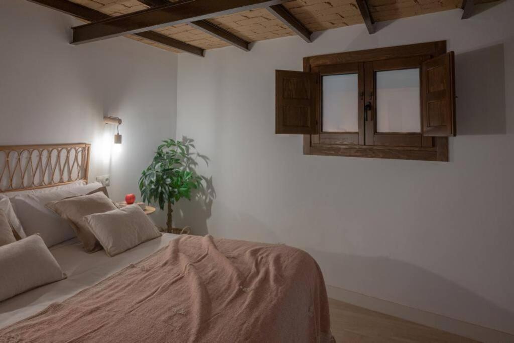 Dormitorio de Muralla Zirí con cama de matrimonio y techo de madera