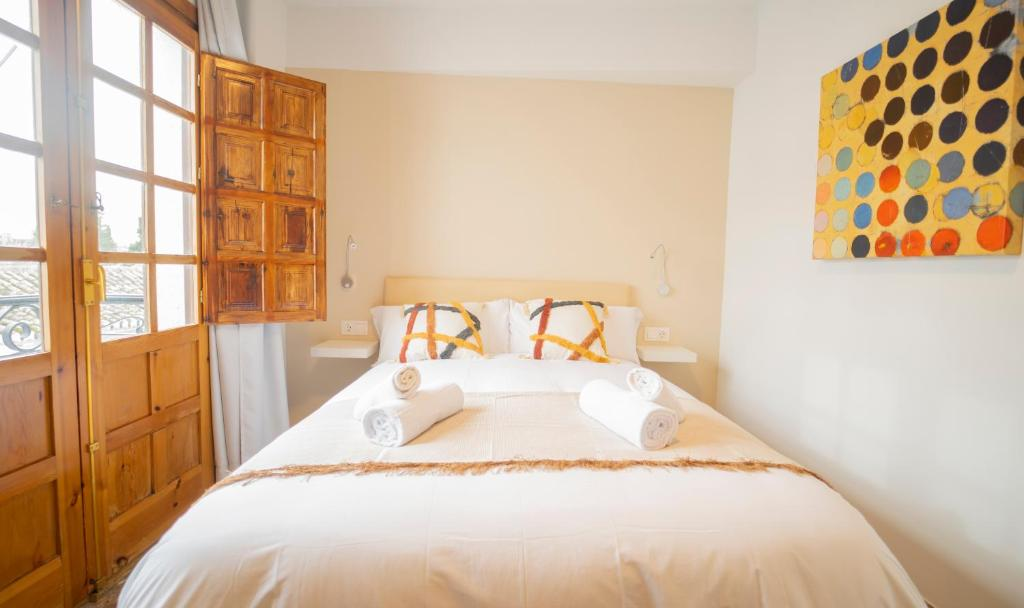 Vista frontal de la cama doble junto al balcón en Carmen San Luis