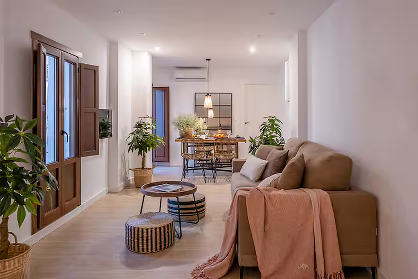 Zona de estar de Arrayanes con sofá cama y comedor al fondo