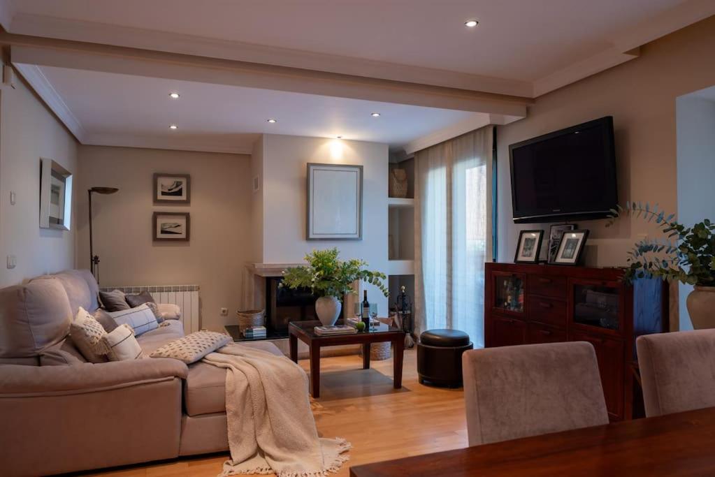 Salón principal de Casa Cortijo del Aire con chimenea y televisión